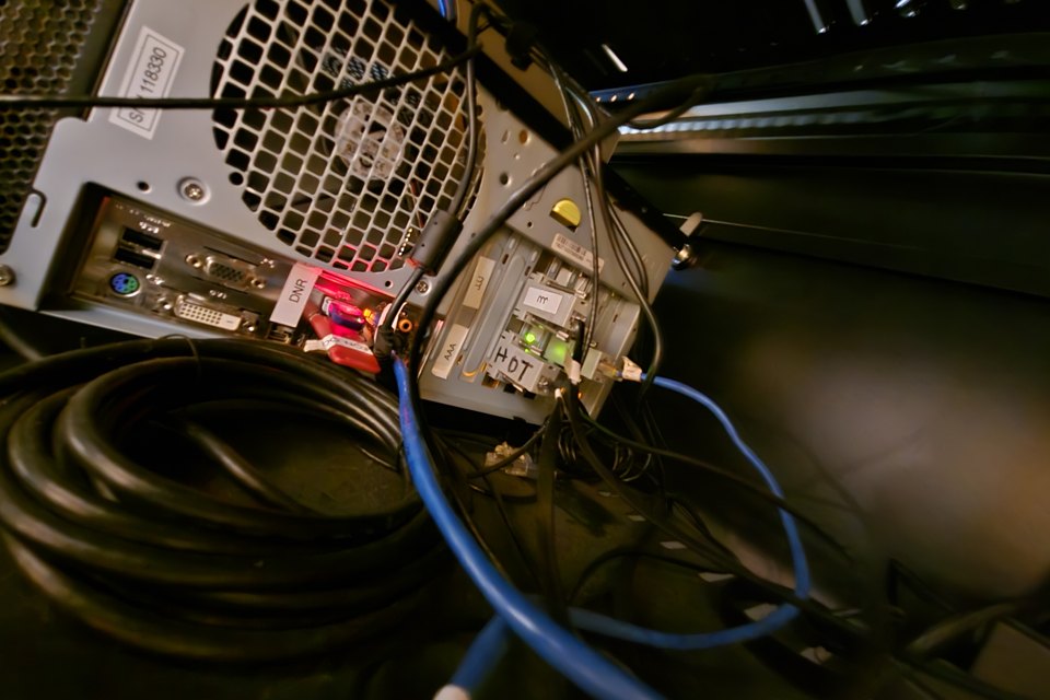 Back of a computer server with Ethernet cables, USB devices and serial-to-Ethernet adapters, illustrating networked runtime dependencies.