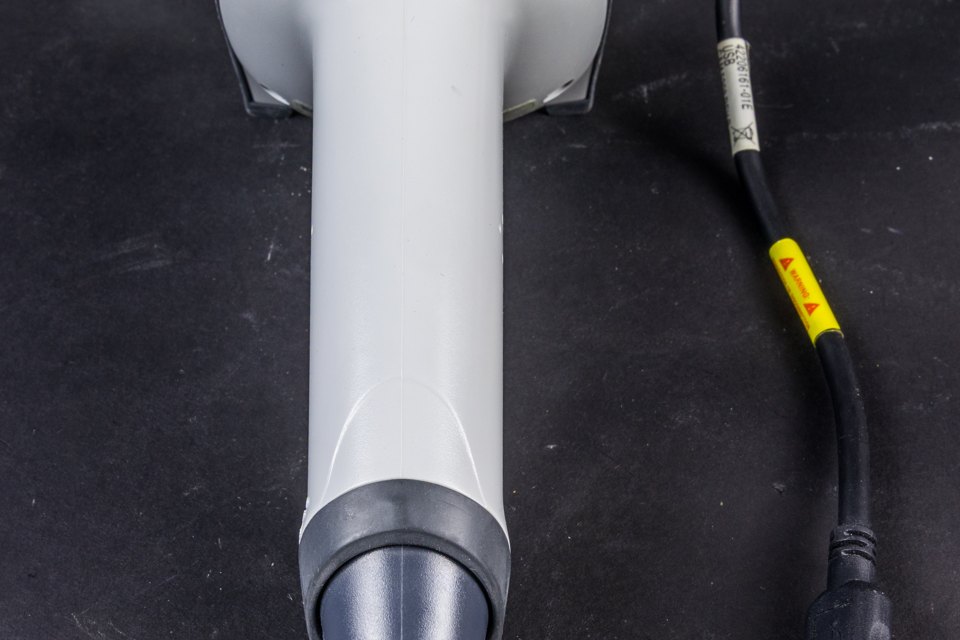 Handheld barcode scanner photographed on a white surface, representing verified operational routing and order handling.